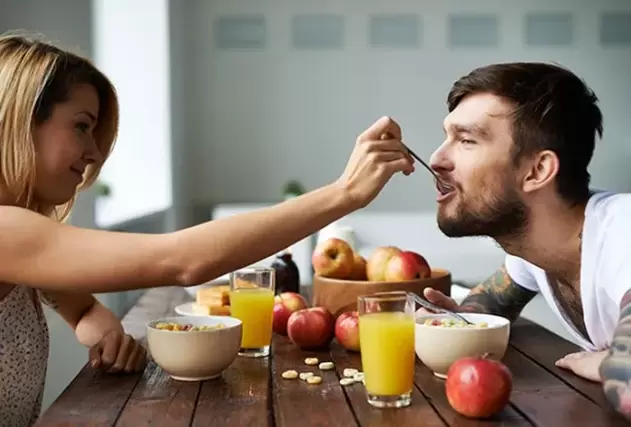 a woman feeds a man nuts to increase her efficiency